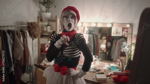 Female mime artist with wearing stage costume and makeup showing comedy performance on camera in theatre dressing roomFemale mime artist with wearing stage costume and makeup showing comedy performanc