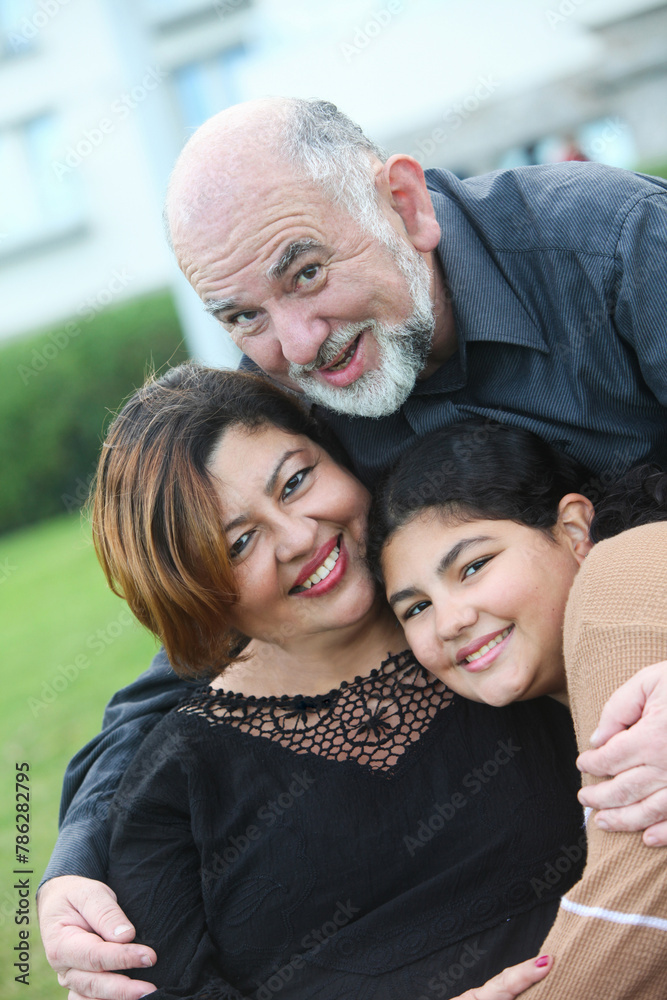 portrait of cheerful mature couple with teenage daughter at the park portrait of cheerful mature couple with teenage daughter at the park