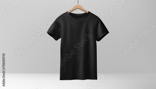 A black tshirt mockup hangs on a wooden hanger against a white backdrop. For showcasing fashion designs for both men and women, providing a realistic presentation. Not AI.