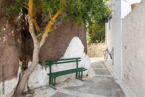 A bench under a tree, a charming place to relax during the hot summer. Nikia village on Nisyros island. Greece © vivoo
