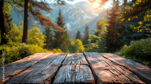 Wooden table in the forest with mountains in the background. Blurred background.