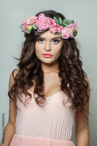 Natural brunette woman with fresh flower on her head. Spring, cosmetic, beauty, skin care and hair care concept