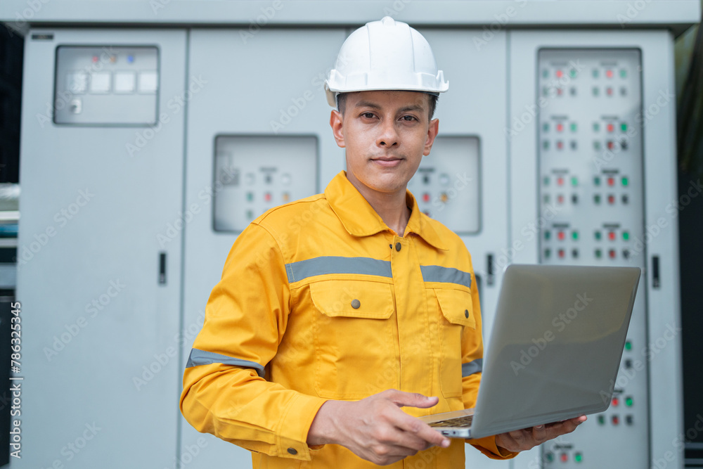Electrical Engineer Monitoring Systems on Laptop Electrical Engineer Monitoring Systems on Laptop