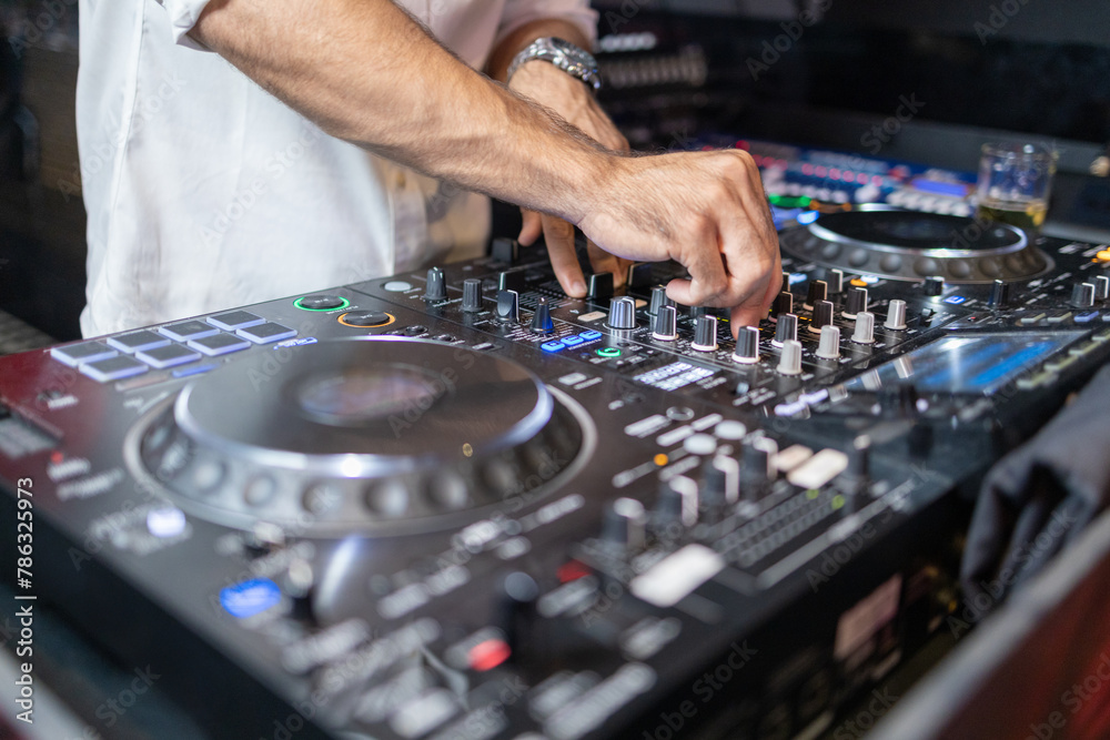 DJ's Hands Adjusting Music Mixer at Event DJ's Hands Adjusting Music Mixer at Event