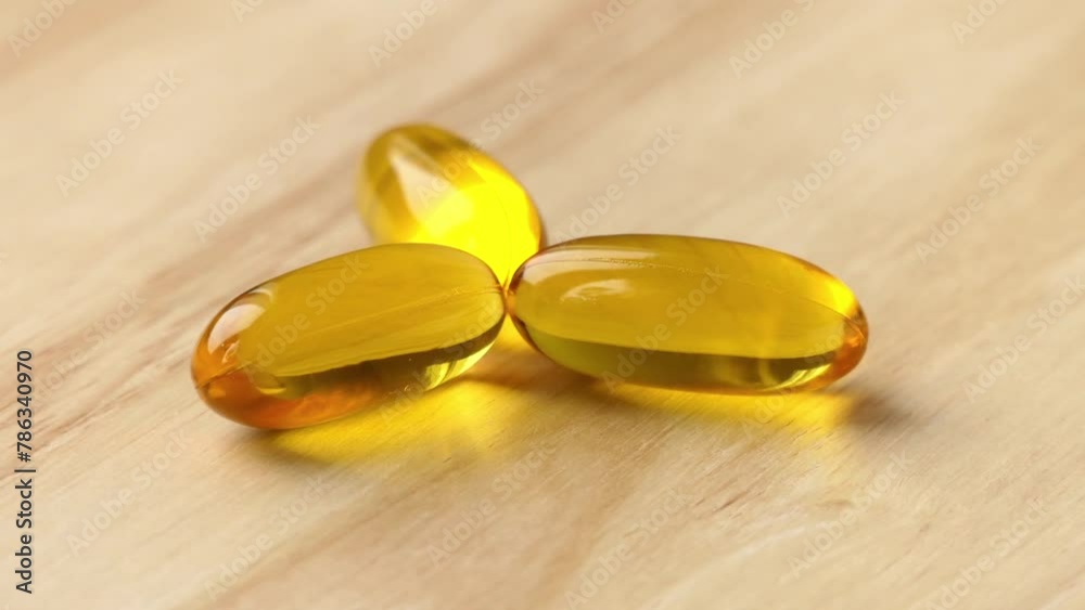 capsules with fish oil lies on a wooden table