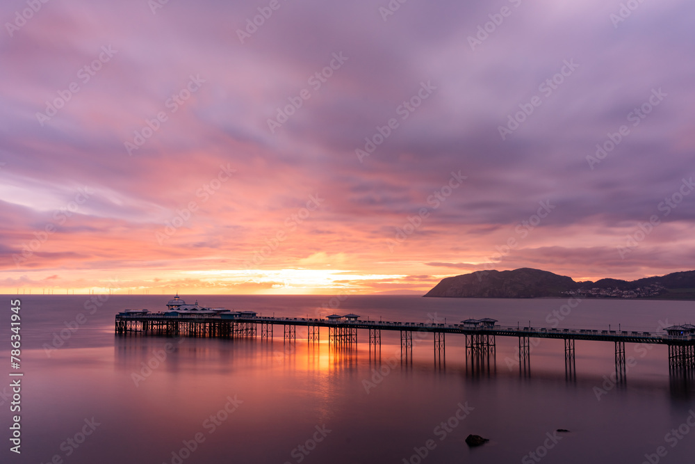 Sunrise over llandudno Pier with the tide in