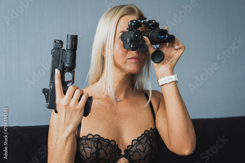 Girl looks through night vision goggles and tactical pistol, close-up photo. photo