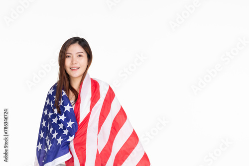 Young woman smiling standing on street holding confident holding united states flag over isolated white background, patriotic holiday. USA celebrate 4th of July. Independence Day concept.