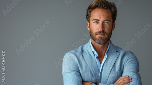 Happy young smiling confident professional business man wearing blue shirt, pretty stylish male executive looking at camera, standing arms crossed at grey background concept.