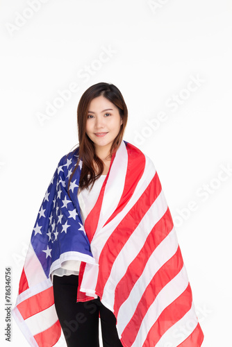Young woman smiling standing on street holding confident holding united states flag over isolated white background, patriotic holiday. USA celebrate 4th of July. Independence Day concept.