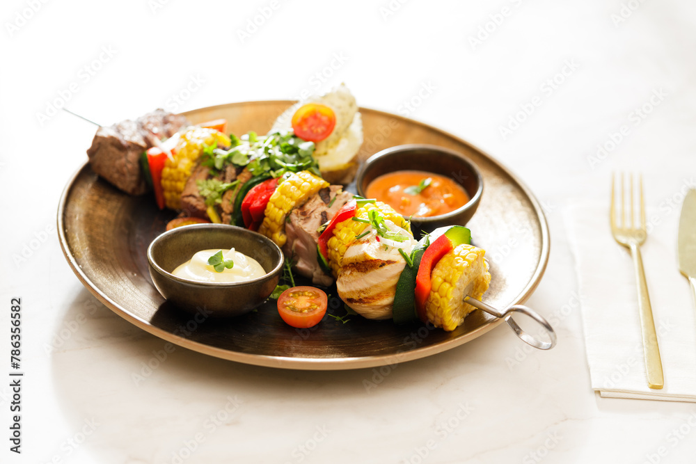 Dutch skewers with corn and cow steak, vegetables and sauce Dutch skewers with corn and cow steak, vegetables and sauce