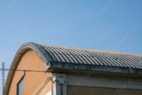 curved industrial roof with asbestos cement corrugations. Asbestos fibers are very dangerous when cut or broken, they cause lung cancer.