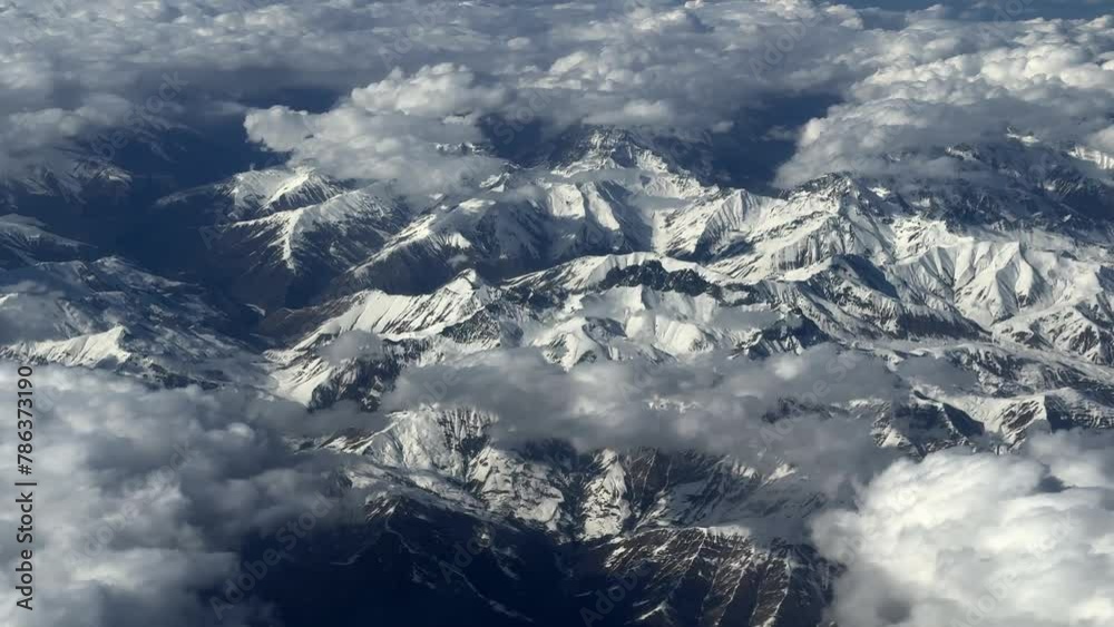 aerial Majestic clouds mountain views from above, airplane, over the snow capped peaks, stunning scene for travel enthusiasts and airline advertising. aerial Majestic clouds mountain views from above, airplane, over the snow capped peaks, stunning scene for travel enthusiasts and airline advertising.