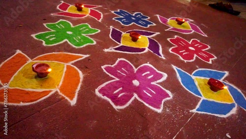 Mysuru, Karnataka, India-November 15 2023; A Close up view of Rangoli decoration in multi colors with Diya lamps during Diwali Hindu festival of lights celebrated across India.
 photo