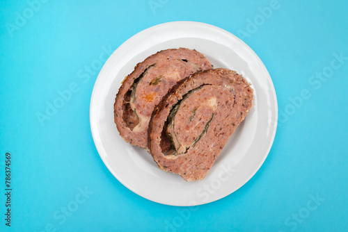 sliced meatloaf with spinach closeup on a white plate