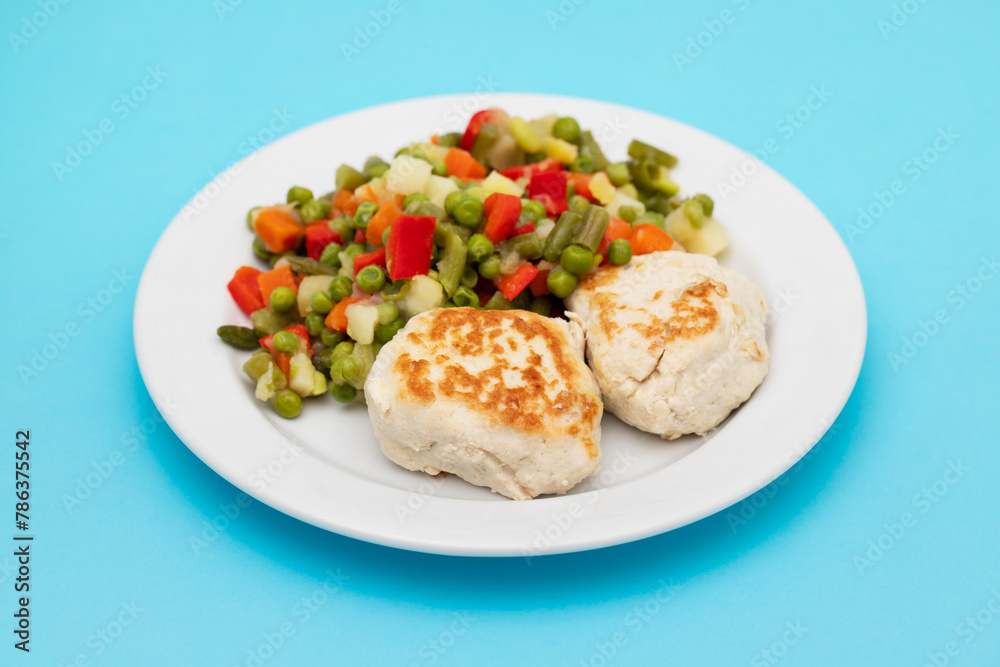 Roasted chicken cutlets with vegetables on white plate Roasted chicken cutlets with vegetables on white plate