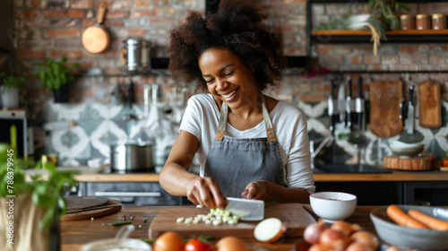 Happy woman cutting onion at table in kitchen