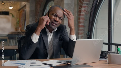 Business problem African American adult manager upset frustrated failure talking mobile phone call conversation hearing bad news middle-aged male worker guy in office businessman man employer headache