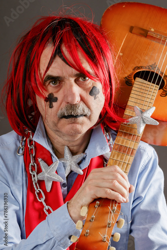 Portrait of an old crazy musician with a guitar