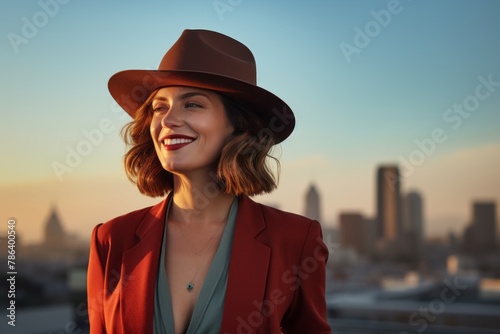Portrait of a glad woman in her 40s donning a classic fedora over vibrant city skyline