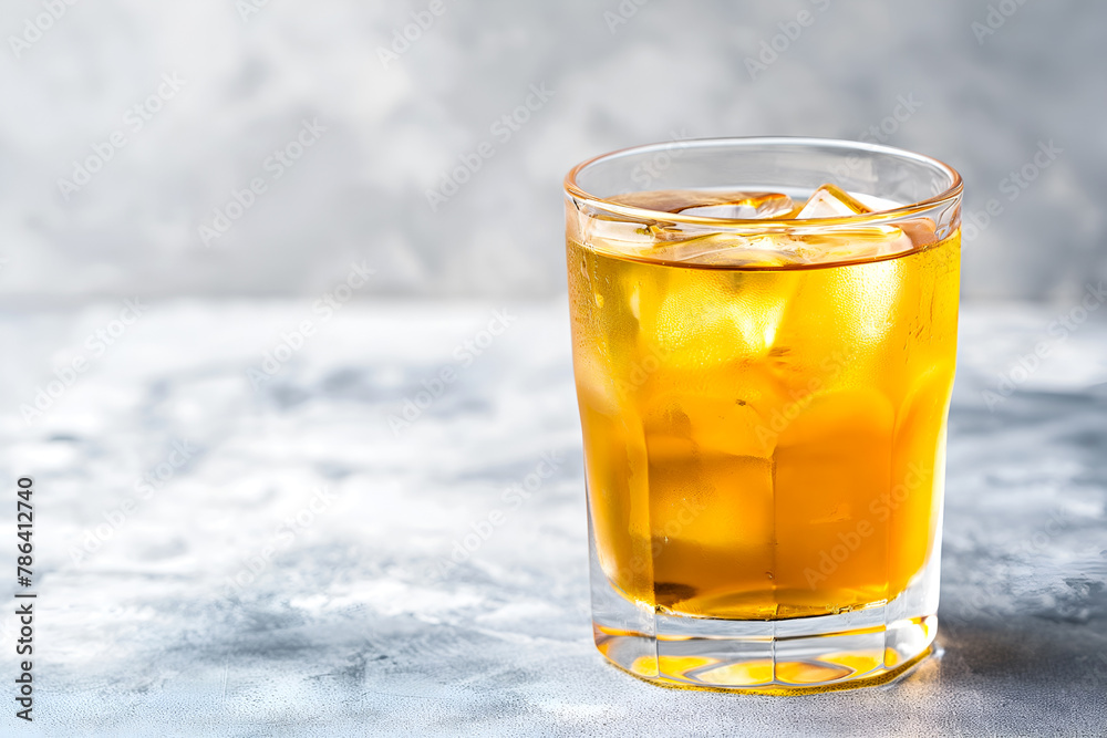 Chilled kombucha tea with ice cubes on light grey background, copy space. Cold kombucha drink in a glass. Iced kombucha beverage, refreshing golden drink. Fermented tea kvass - obrazy, fototapety, plakaty 