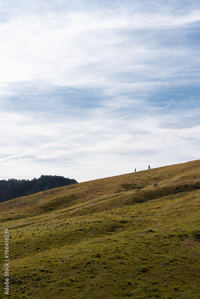 People walking on a ridge of a mountain in Stoos, Switzerland. Swiss Alps iconic aerial view People walking on a ridge of a mountain in Stoos, Switzerland. Swiss Alps iconic aerial view