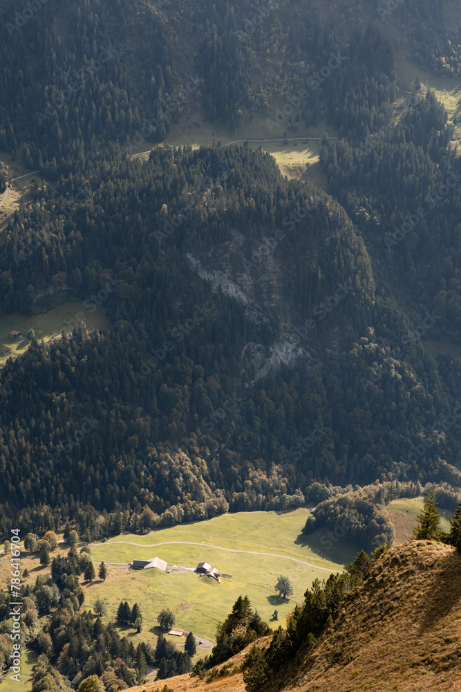 View of a valley in Swiss Alps. Bright sunny day with low clouds in Switzerland