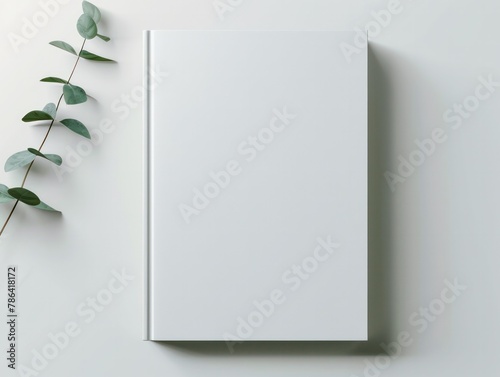 empty blank white book cover mock up and green eucalyptus branch on white table background