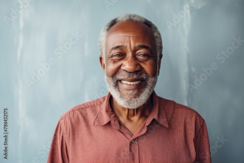 Portrait of a smiling afro-american elderly man in his 90s dressed in a relaxed flannel shirt isolated in modern minimalist interior