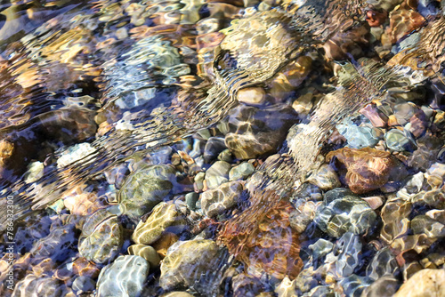 clear water flowing over rocks in a shallow stream of water
