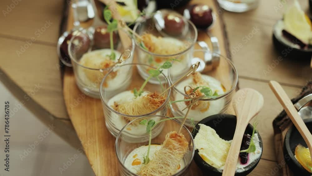 Wooden tray with glasses of food and spoons, displayed on a table Wooden tray with glasses of food and spoons, displayed on a table