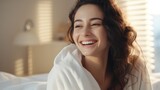 A joyful woman in a bathrobe enjoys morning light Suitable for lifestyle magazines, wellness blogs, spa and hotel promotions, beauty product ads, and happiness-themed campaigns