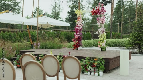 Floraldecorated stage with chairs, creating a romantic wedding setting. Wedding arch photo