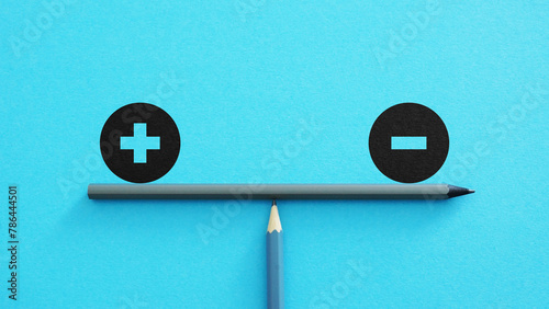 Plus and minus or positive and negative symbols are in balance on a scales with blue background. Pros and cons