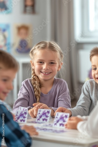 Happy 7-year-old boys and girls having a blast with a delightful card game during their indoor playtime photo