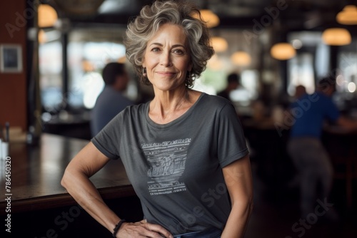 Portrait of a blissful woman in her 60s dressed in a casual t-shirt while standing against bustling city cafe