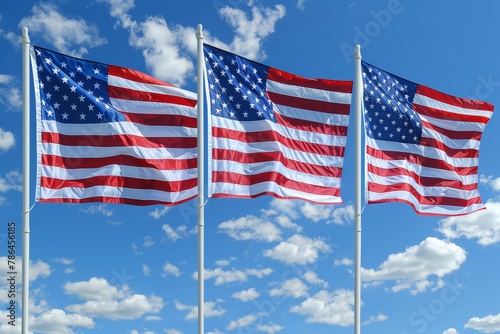 Trio of American flags fluttering in the breeze, symbolizing unity and patriotism under a clear blue sky with clouds..