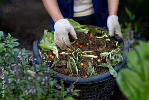 Composting, farmer mixes food waste with soil for compost