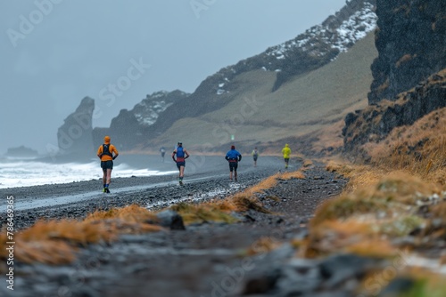 Group of people competitively running on wet beach during race in Iceland.