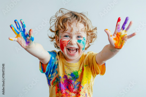 Happy child boy with paint on her hands jumping and laughing in a children s room  on a white background with space for copy text  in the style of color splashes.