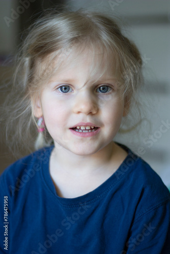 Close up portrait of a happy smiling 4 year old girl. Young blonde cute child looking at the camera
