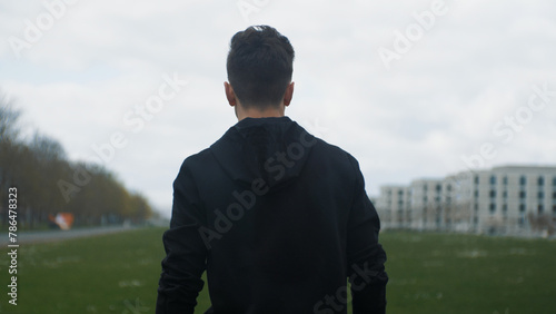 A young man walks forward in the rain. Moving forward. Motivation