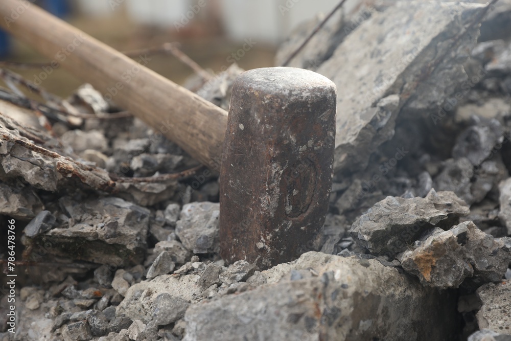 Sledgehammer on pile of broken stones outdoors, closeup Sledgehammer on pile of broken stones outdoors, closeup