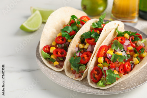 Tasty tacos with vegetables on white marble table, closeup