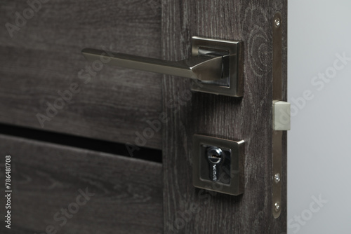 Open wooden door with metal handle, closeup photo