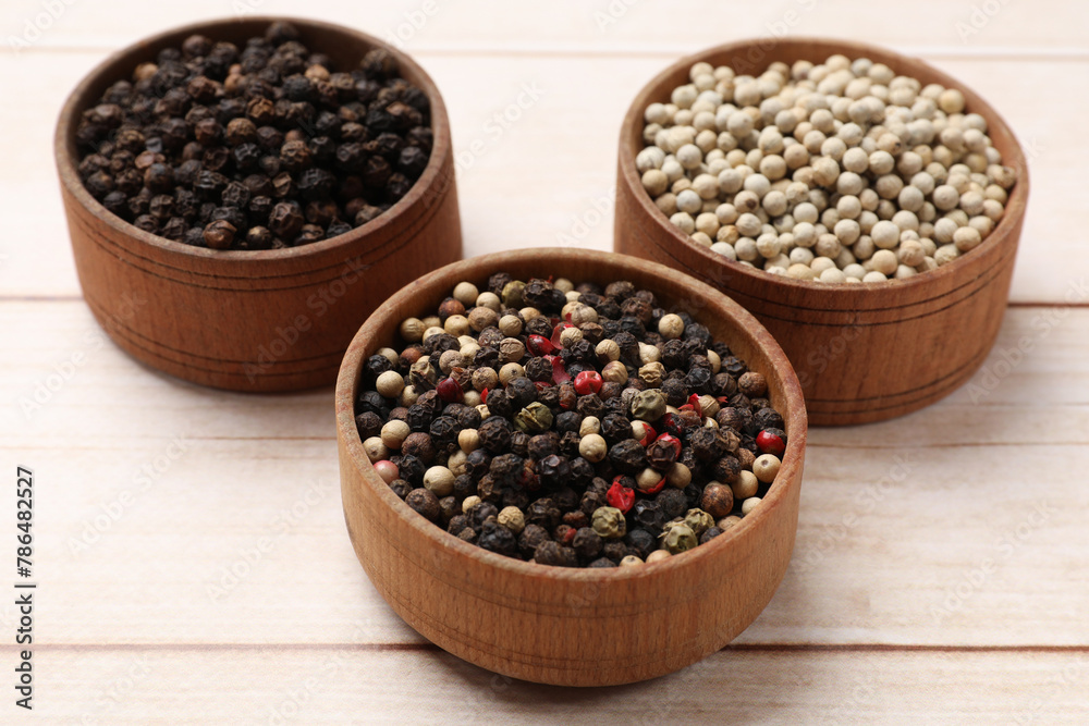 Aromatic spices. Different peppers in bowls on wooden table Aromatic spices. Different peppers in bowls on wooden table