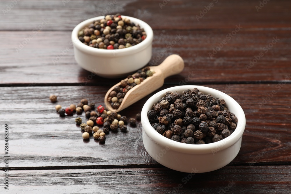 Aromatic spice. Different peppers in bowl and scoop on wooden table Aromatic spice. Different peppers in bowl and scoop on wooden table