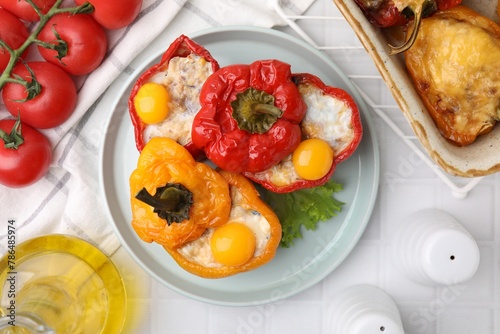Delicious stuffed bell peppers served on white tiled table, flat lay