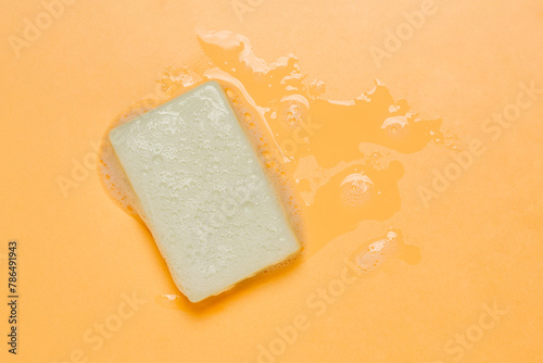 bar of olive oil soap with foam on orange