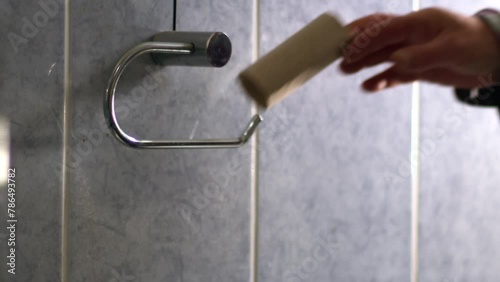 Hand changing toilet roll in bathroom  photo